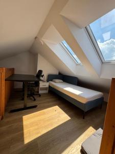 a bedroom with a bed and a desk in a attic at StayCentralcz- Loft in Opava
