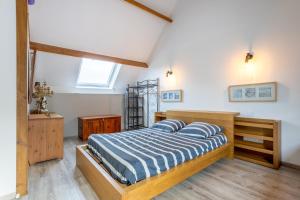 a bedroom with a bed with a blue and white comforter at Domaine de Kerroux in Bannalec