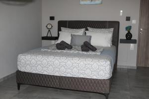 a large bed with two pairs of shoes on it at Villa Joanna Seasides , Top Floor in Mesimérion