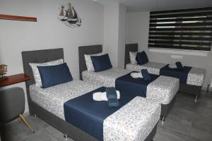 a room with four beds with blue pillows at Villa Joanna Seasides , Top Floor in Mesimérion