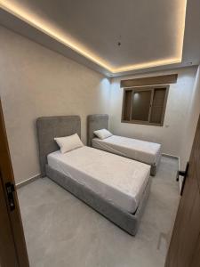 two beds in a small room with a window at اقامة هبة 2 in Yebha