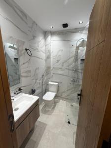 a bathroom with a toilet and a sink and a shower at اقامة هبة 2 in Yebha