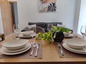 a wooden table with plates and silverware on it at Blue bay Sliema in Sliema