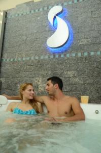 a man and a woman are in a pool of water at Ñikén Hotel Spa & Business Center in Necochea