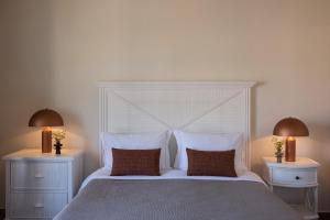 a bedroom with a large white bed with two night stands at Porto Kea Suites by Sandglass in Korissia +73 photos