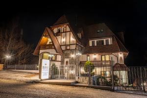 a house with a sign in front of it at night at RUELLE Chateau Boutique- adults only in Sinaia