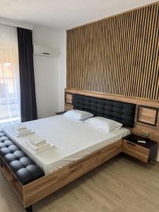 a bedroom with a large bed with a wooden headboard at Golden Sands in Keramoti