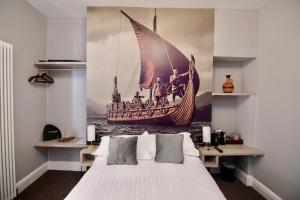 a bedroom with a bed with a painting of a ship at Vikings Accommodation in York
