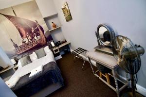 a bedroom with a bed and a fan and a desk at Vikings Accommodation in York