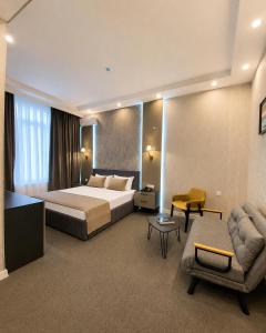 a large hotel room with a bed and a couch at Mountain-city in Zaqatala