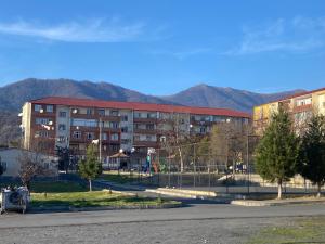 a large building with mountains in the background at Mountain-city in Zaqatala