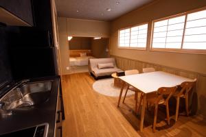 a kitchen with a table and a couch and a bedroom at Shiosai HIRADO in Hirado