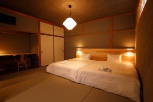 a bedroom with a large white bed and a desk at Shiosai HIRADO in Hirado +15 photos