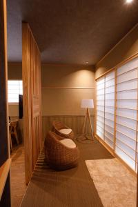 a living room with two ottomans and a table and a lamp at Shiosai HIRADO in Hirado