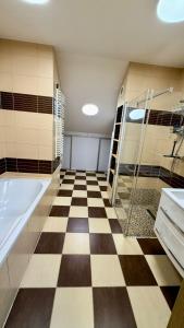 a bathroom with a checkered floor and a bath tub at Rynek 30 in Leżajsk +19 photos