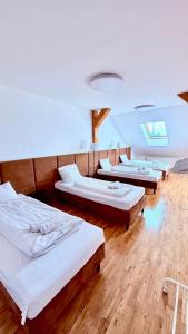a row of beds in a room with wooden floors at Rynek 30 in Leżajsk