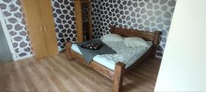 a bedroom with a wooden bed with a table on it at Ligzdas in Valgalciems