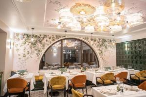 a restaurant with white tables and chairs and a large mirror at RUELLE Chateau Boutique- adults only in Sinaia