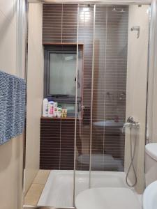 a bathroom with a shower and a toilet and a television at Blue bay Sliema in Sliema +20 photos