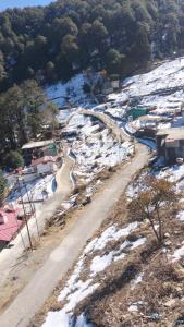 an aerial view of a snow covered mountain with a road at Celestia peaks in Bhowāli