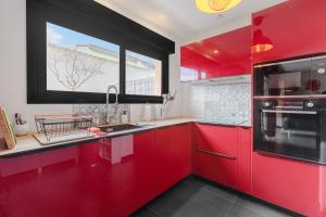 a kitchen with red cabinets and a window at Modern townhouse with parking in Toulouse