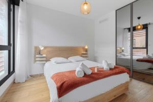 a white bedroom with a large bed and a mirror at Modern townhouse with parking in Toulouse