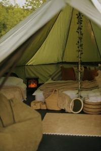 a green tent with a bed and a chair in it at Debed Glamping in Debed