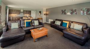 a living room with leather couches and a coffee table at Scott's Hotel in Killarney