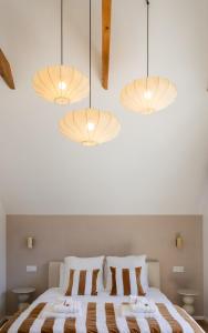 a bedroom with a bed with three lights at Maison VENELL Concarneau - Spa, Balnéo, Sauna & Jardin - Calme en Centre-ville in Concarneau