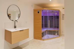 a bathroom with a shower and a sink and a mirror at Maison VENELL Concarneau - Spa, Balnéo, Sauna & Jardin - Calme en Centre-ville in Concarneau +28 photos