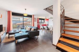 a living room with a blue couch and a staircase at Modern townhouse with parking in Toulouse