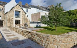 a stone retaining wall in front of a house at Maison VENELL Concarneau - Spa, Balnéo, Sauna & Jardin - Calme en Centre-ville in Concarneau