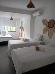 two beds in a room with white walls at Villa Sol hospedaria in Paty do Alferes +77 photos