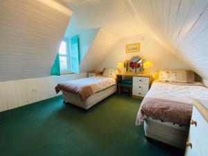 a attic bedroom with two beds and a desk at The Kennels Ellary in Lochgilphead