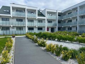 an apartment building with a walkway in front of it at Apartament Berlinek in Grzybowo
