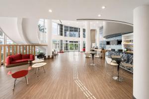 a living room with a red couch and chairs at Slim Hotel Campinas in Campinas