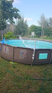 a swimming pool with a net in the grass at Cabana Relax in Râmnicu Vâlcea