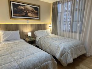 a hotel room with two beds and a window at CASA ETEN Hospedaje Boutique - centro histórico de Cajamarca in Cajamarca