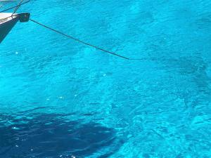 a boat in the blue water with a rope at Loggos Harbour Suites in Longós
