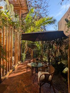 a patio with a table and chairs and an umbrella at Hotel Boutique Terra Diaguita & Spa in La Serena