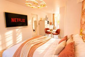 a bedroom with a bed with a netflix sign on the wall at MRODBNB - Escapade Romantique - Appart Neuf- 25m Plage & Resto - Ciné - Popcorn - Ciel de Pluie XXL in Cancale
