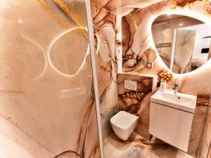 a bathroom with a toilet and a sink and a mirror at MRODBNB - Escapade Romantique - Appart Neuf- 25m Plage & Resto - Ciné - Popcorn - Ciel de Pluie XXL in Cancale