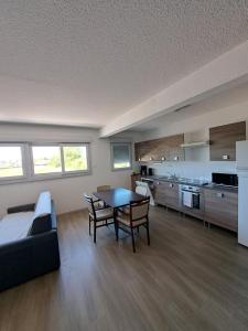 a living room with a table and a kitchen at Zenao Appart's Yzeure in Yzeure