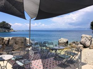 a group of chairs and tables and an umbrella on the beach at Loggos Harbour Suites in Longós +52 photos