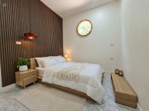 a bedroom with a large bed and a clock on the wall at Villa Vista in Wok Tum +7 photos