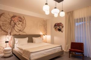 a bedroom with a bed with a painting on the wall at RUELLE Chateau Boutique- adults only in Sinaia