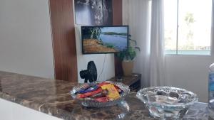 a kitchen counter with a television on a wall at Cantinho da Alzira - Sobrado in Iguaba Grande