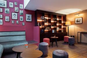 a bar with pink walls and tables and stools at Hôtel Sanso by HappyCulture in Paris