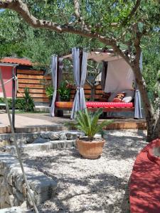 a bed in a tent under a tree at Villa D`Amante in Klis