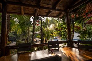 a dining room with a table and chairs and trees at La Bicok EcoLodge in Mindo